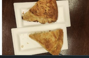 Fresh spanakopita triangles on a plate