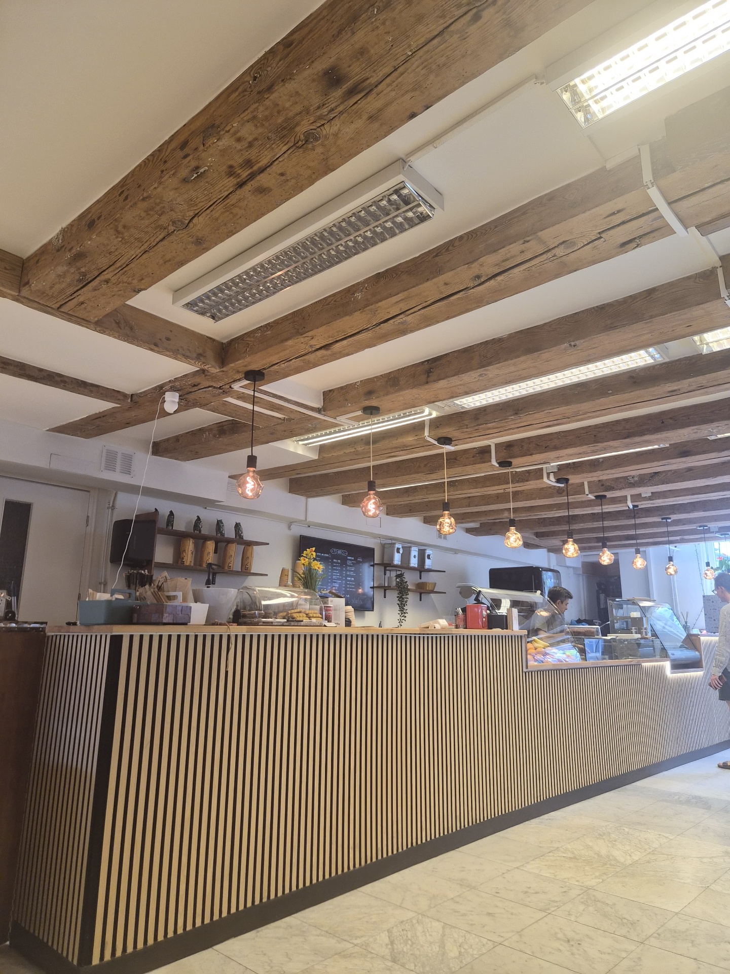Fournos counter with wooden beams and pendant bulbs